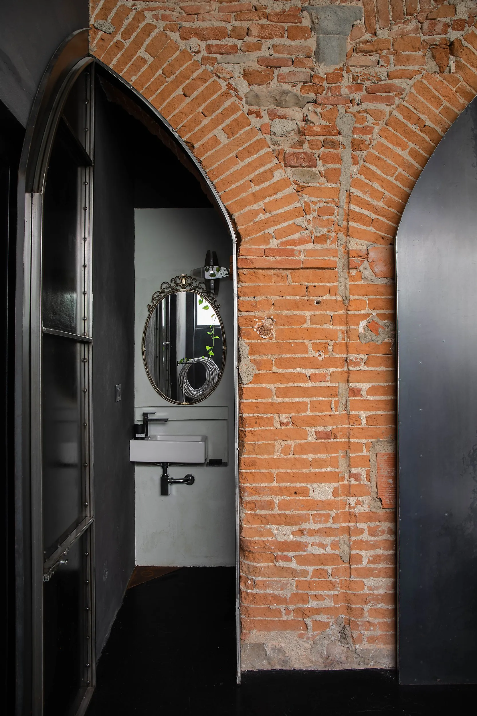 The riveted iron wall swung open on the washroom, under the exposed brick vault