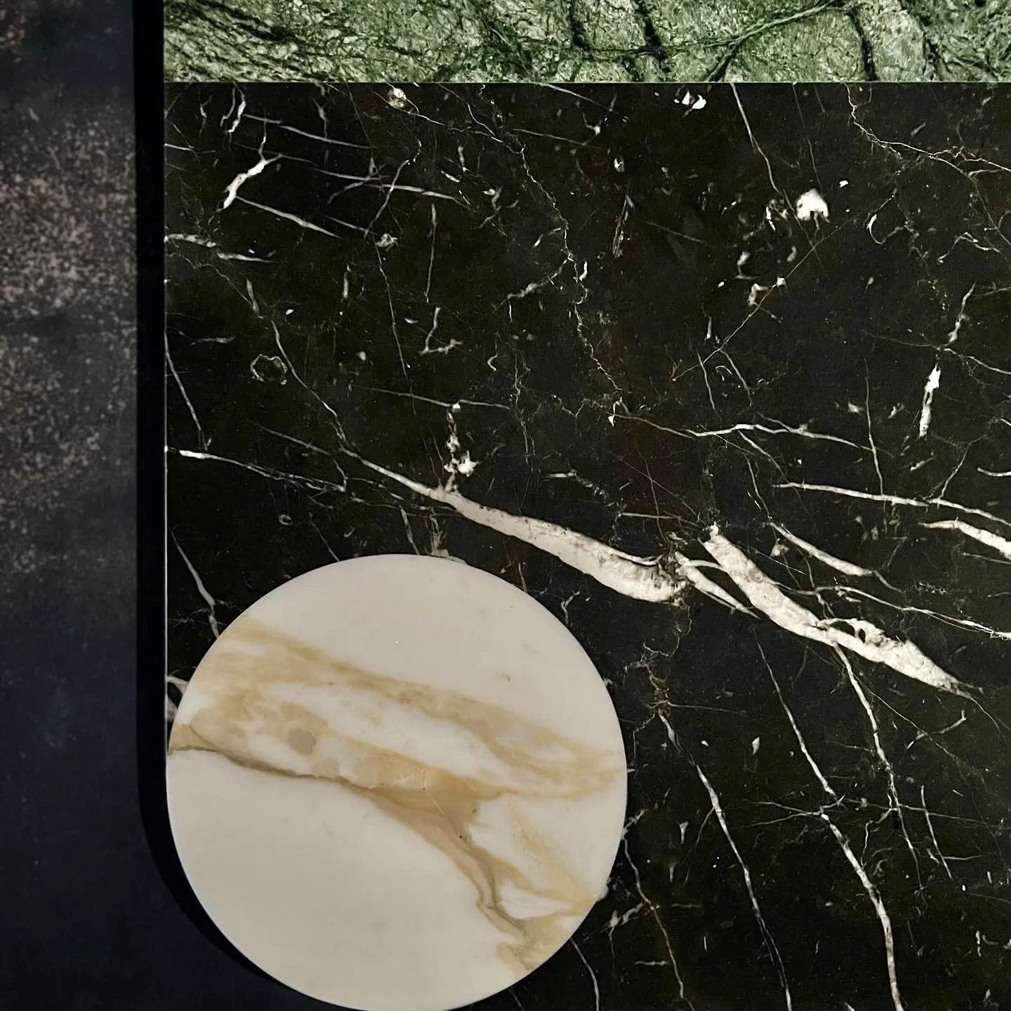 Chimera centrepiece in detail: black marble veined with white, and a marble disc