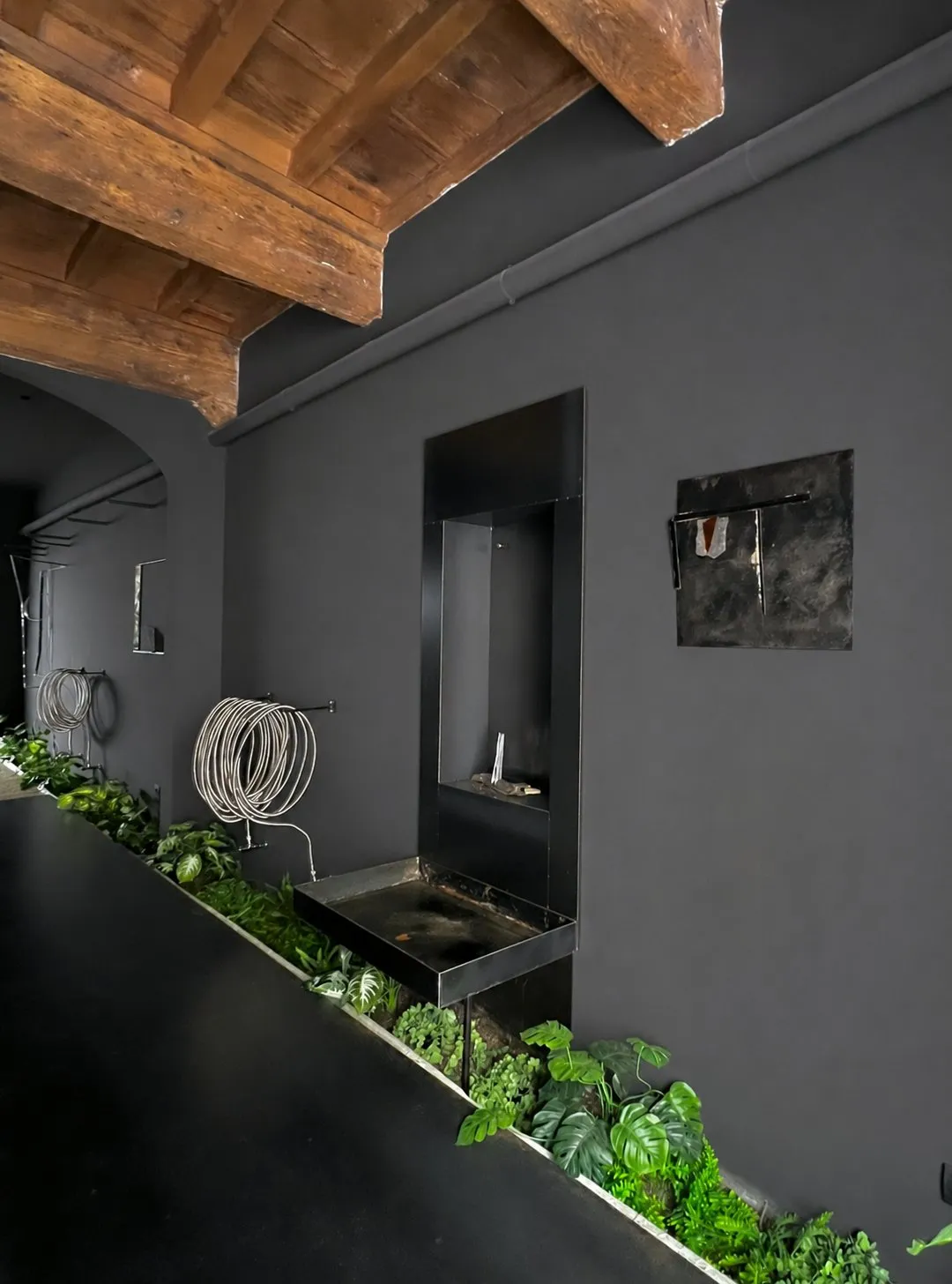 The room in profile: the iron niche holding a small work, a dark relief on the wall beside it