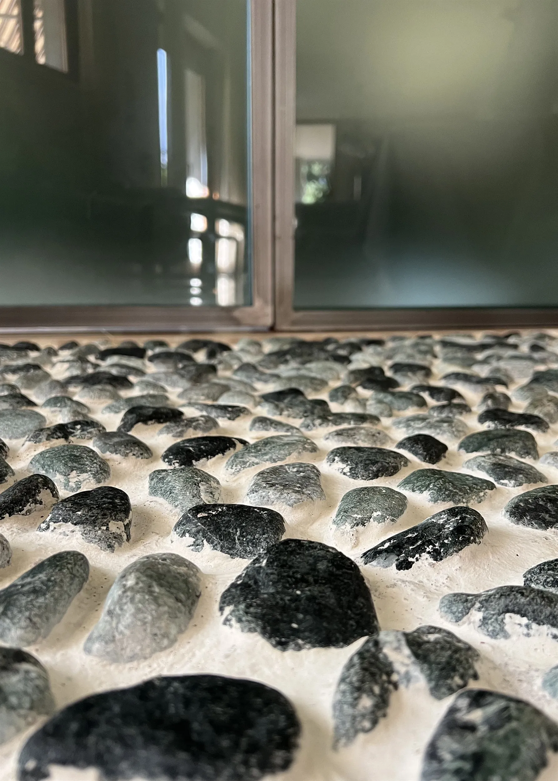 A strip of green river pebbles set into the floor